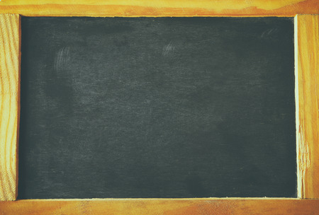 vintage wooden blackboard on wooden table with space for text.