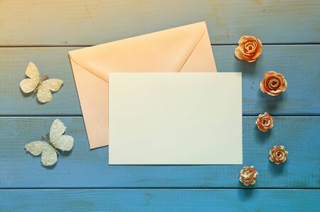 vintage mockup with flowers and blank letter on wooden background. vintage filtered and toned