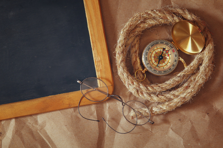 top view of compass, rope, old glasses and blank blackboard. explorer and adventure concept. vintage filteredの写真素材
