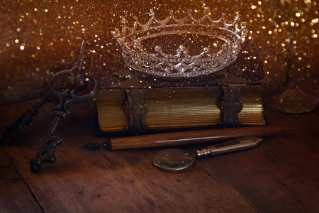 low key image of beautiful diamond queen crown on old book. vintage filtered with glitter overlay. fantasy middle age conceptの写真素材