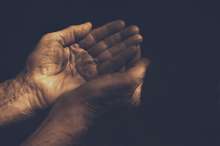 male Wrinkled old hands begging asking for money, help, reaching out and compassion conceptの写真素材