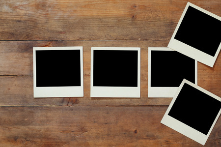 top view of blank instant photos album on wooden background. vintage filtered image. ready to put imagesの写真素材
