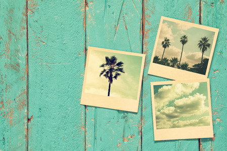 top view of instant photos album on wooden background. vintage filtered imageの写真素材