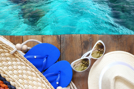 top view of sea and wooden deck with beach accessories