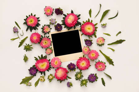Top view of beautiful pink flowers and empty photo frame on white background. Copy spaceの写真素材