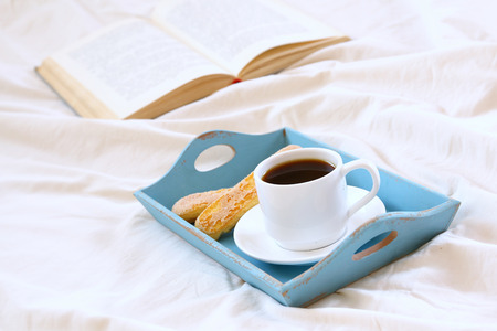 Romantic breakfast in the bed: cookies, hot coffees and open bookの写真素材