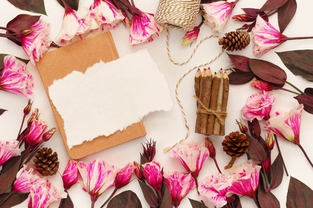 Top view of beautiful flowers and sketchbook on white background. Copy spaceの写真素材