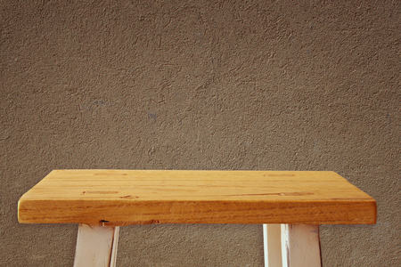 Empty small table in front of old wall background. For product displayの写真素材