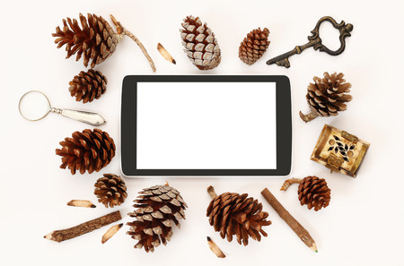 Top view of tablet with blank screen and pine cones on white backgroundの写真素材