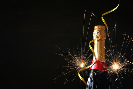 Champagne bottle in front of black background. New year and celebration conceptの写真素材