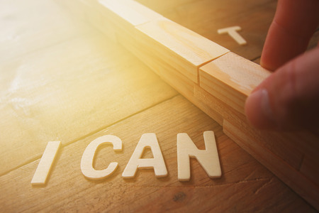 Image of wall between letters I CAN'T, cutting the letter T so it written I CAN. Success and challenge conceptの写真素材