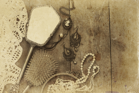 Top view image of vintage woman toilet fashion objects on old wooden table. Sepia antique style filtered photoの写真素材