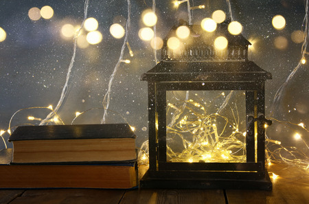 low key and vintage filtered image of fairy lights inside old lantern and antique books. Fairy tale conceptの写真素材
