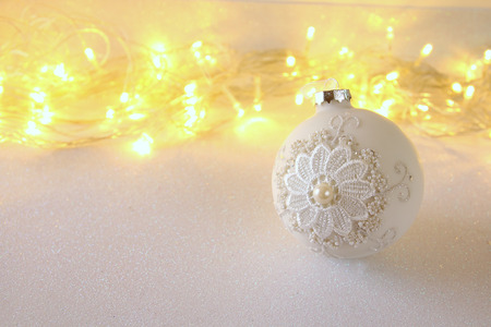 Image of christmas festive tree white ball decoration in front of silver glitter backgroundの写真素材