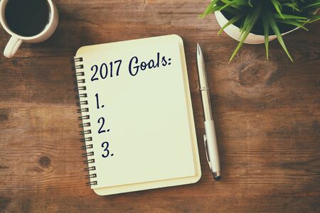 Top view 2017 goals list with notebook, cup of coffee on wooden deskの写真素材