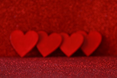 Valentines day background. Wooden red hearts on red shiny backgroundの写真素材