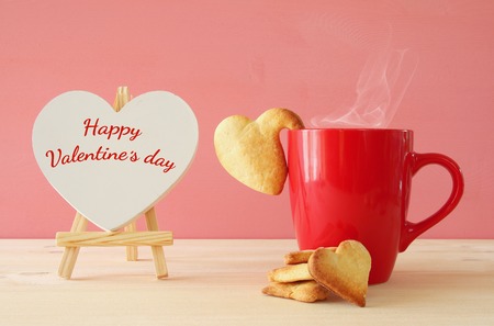 Valentines day background. Cup of coffe and heart shape cookies on the tableの写真素材