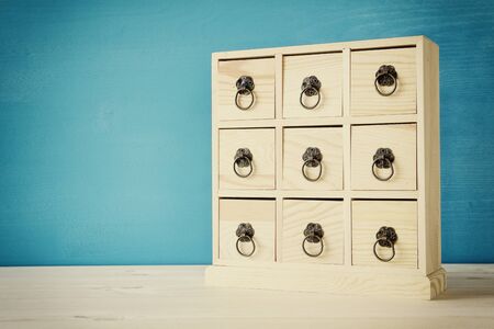 Image of natural wooden antique chest with drawers and metal handles. Filtered and tonedの写真素材