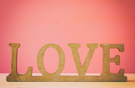 Image of the word LOVE from wooden letters and heart over the table. Filtered and tonedの写真素材