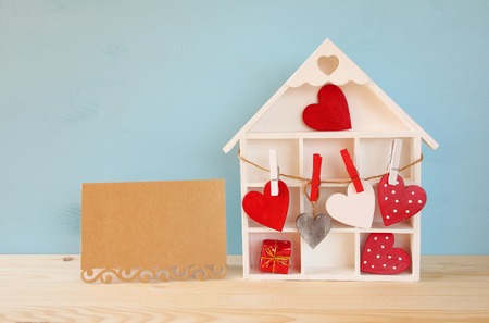 Valentines day background. Wooden house with many hearts next to letter on the tableの写真素材