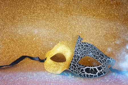 Image of elegant venetian mask on gold glitter backgroundの写真素材