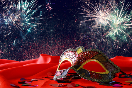 Image of elegant venetian mask on red silk and glitter shiny backgroundの写真素材