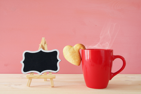 Valentines day background. Cup of coffe and heart shape cookies on the tableの写真素材