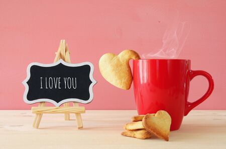 Valentines day background. Cup of coffe and heart shape cookies on the tableの写真素材