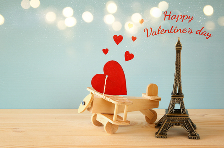 Valentines day background. Wooden plane with heart next to Eiffel Tower on the tableの写真素材