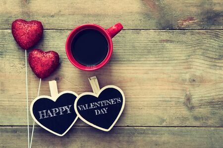 Valentines day background. Couple of red glitter hearts and chalkboard on wooden background. Flat lay compositionの写真素材