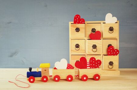 Wooden toy train with hearts on the table.の写真素材