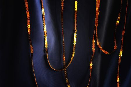 Elegant soft blue silk background with gold sparkle sequins. Glitter overlay