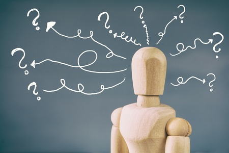 image of wooden dummy with may question marks. Confusion and doubt conceptの写真素材