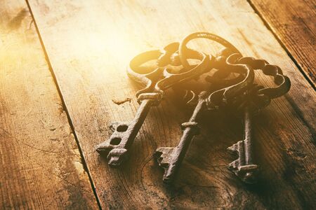 close up image of vintage skeleton keys over wooden table and bright light as reveletaion conceptの写真素材