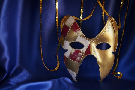 Image of elegant gold venetian mask on blue silk backgroundの写真素材