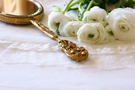 Background of white delicate lace fabric, hand mirror and white flowersの写真素材