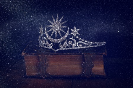 low key image of beautiful diamond queen crown on old book. vintage filtered with glitter overlay. selective focus. medieval period conceptの写真素材