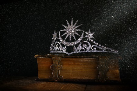 low key image of beautiful diamond queen crown on old book. vintage filtered. selective focus. medieval period conceptの写真素材