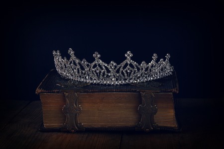 low key image of beautiful diamond queen crown on old book. vintage filtered. selective focus. medieval period conceptの写真素材