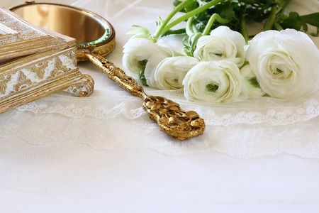 Background of white delicate lace fabric, hand mirror and white flowersの写真素材