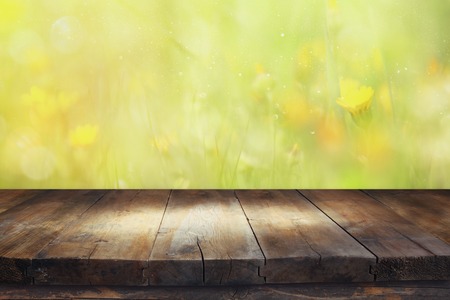 Empty rustic table in front of spring beautiful field flowers background. product display and picnic conceptの写真素材