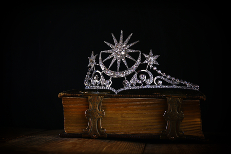 low key image of beautiful diamond queen crown on old book. vintage filtered. selective focus. medieval period conceptの写真素材