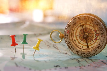 pins attached to map, showing location or travel destination and old compass. selective focus.の写真素材