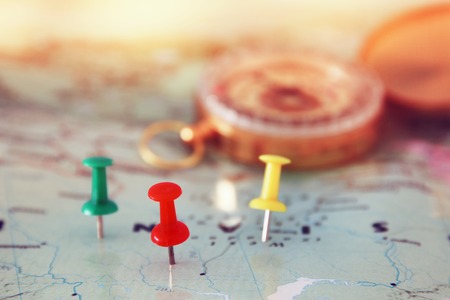 pins attached to map, showing location or travel destination and old compass. selective focus.の写真素材