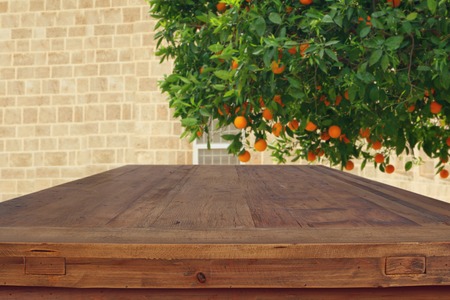 Empty rustic table in front of countryside orange tree background. product display and picnic conceptの写真素材