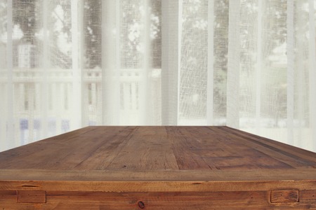 image of wooden table in front white curtains. for product display and presentationの写真素材