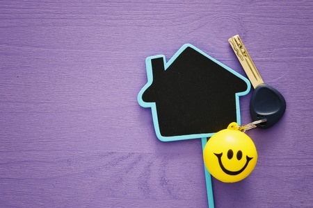 image of new house keys and house shaped sign over wooden tableの写真素材