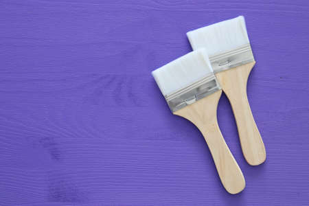 Top view image of paint brushes on purple wooden backgroundの写真素材