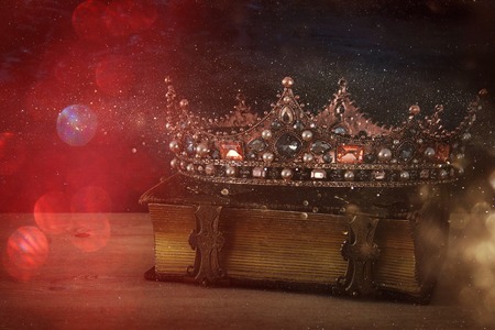 low key image of beautiful queen/king crown on old book. vintage filtered. fantasy medieval periodの写真素材