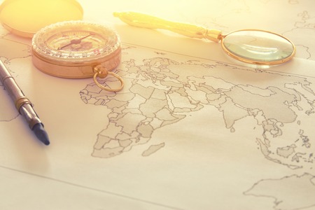 Image of map, magnifying glass and old compass. selective focus. travel destination concept